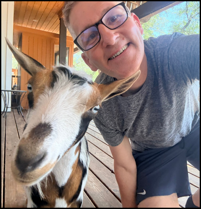 Lee Reichel, M.D. outdoors with a goat.